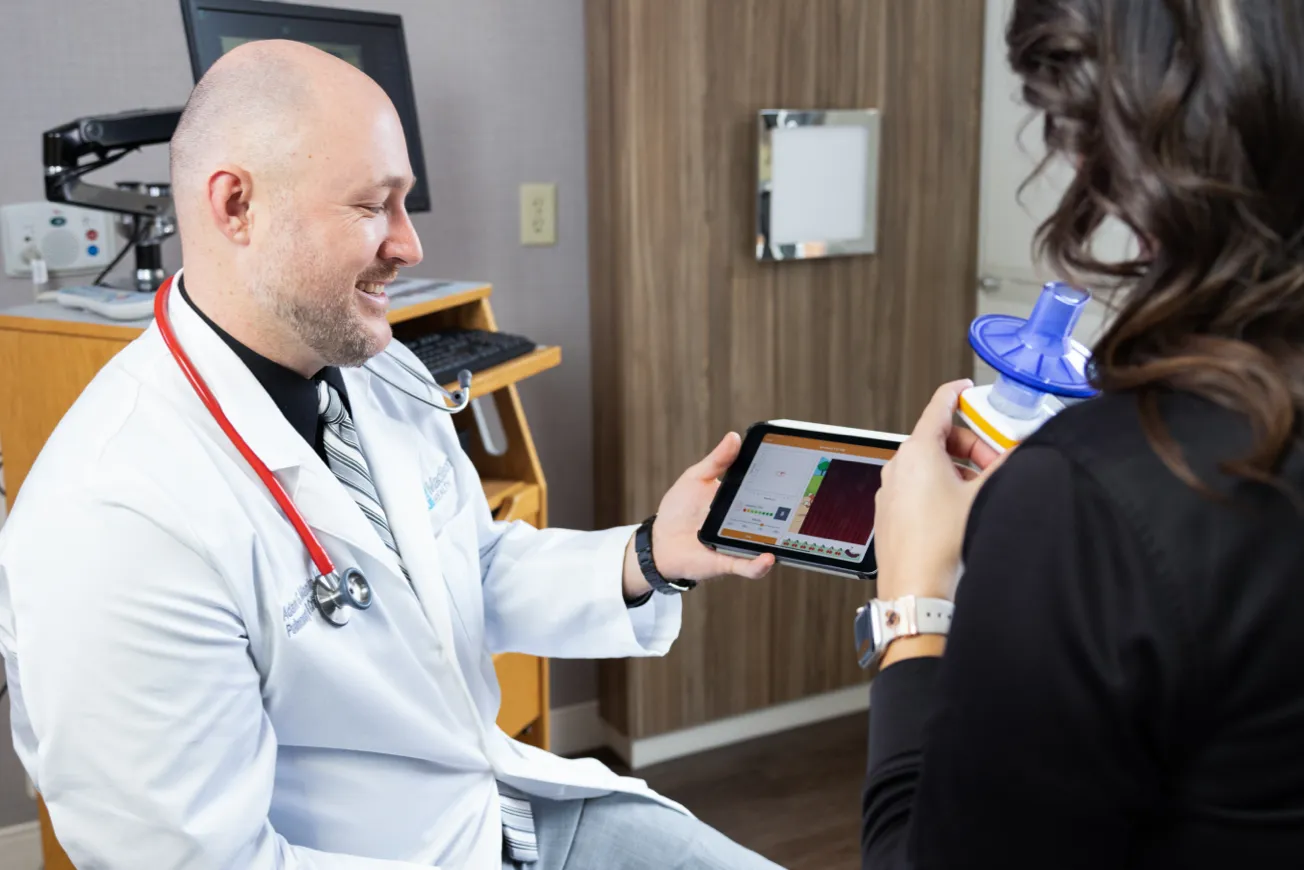 doctor smiling at iPad screen with patient