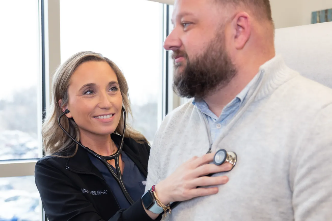 Madison Health physician listening to patient heart.