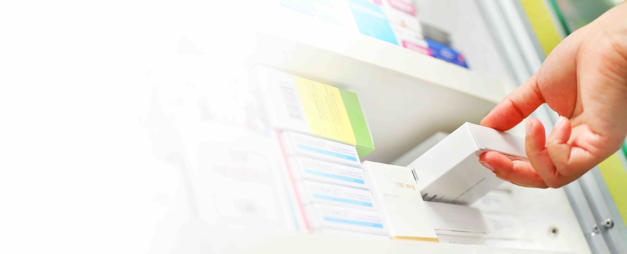 Closeup pharmacist hand holding medicine box in pharmacy drugstore.Space for text on white background