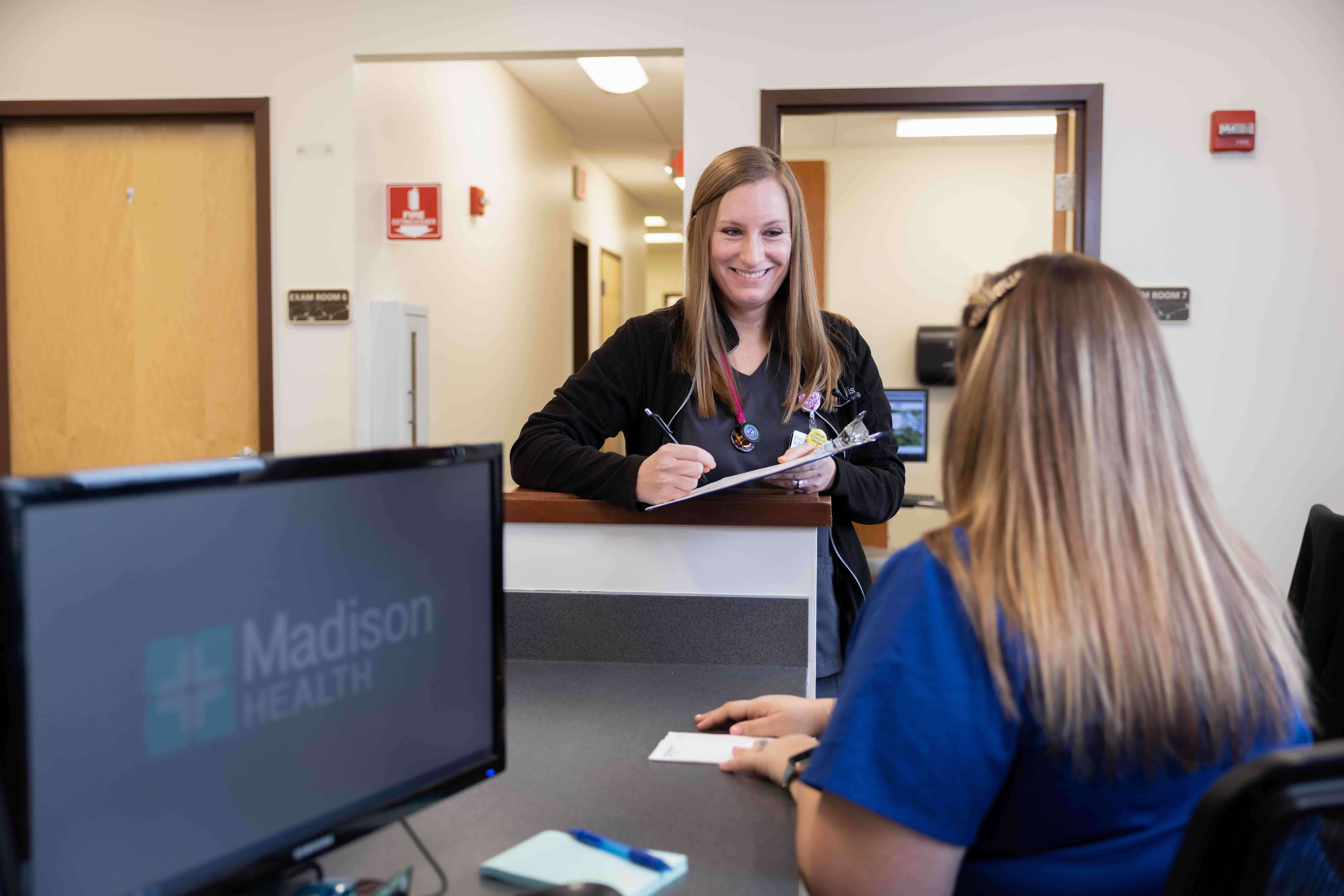 Madison Health About Us, Provider at hospital counter with Nurse.