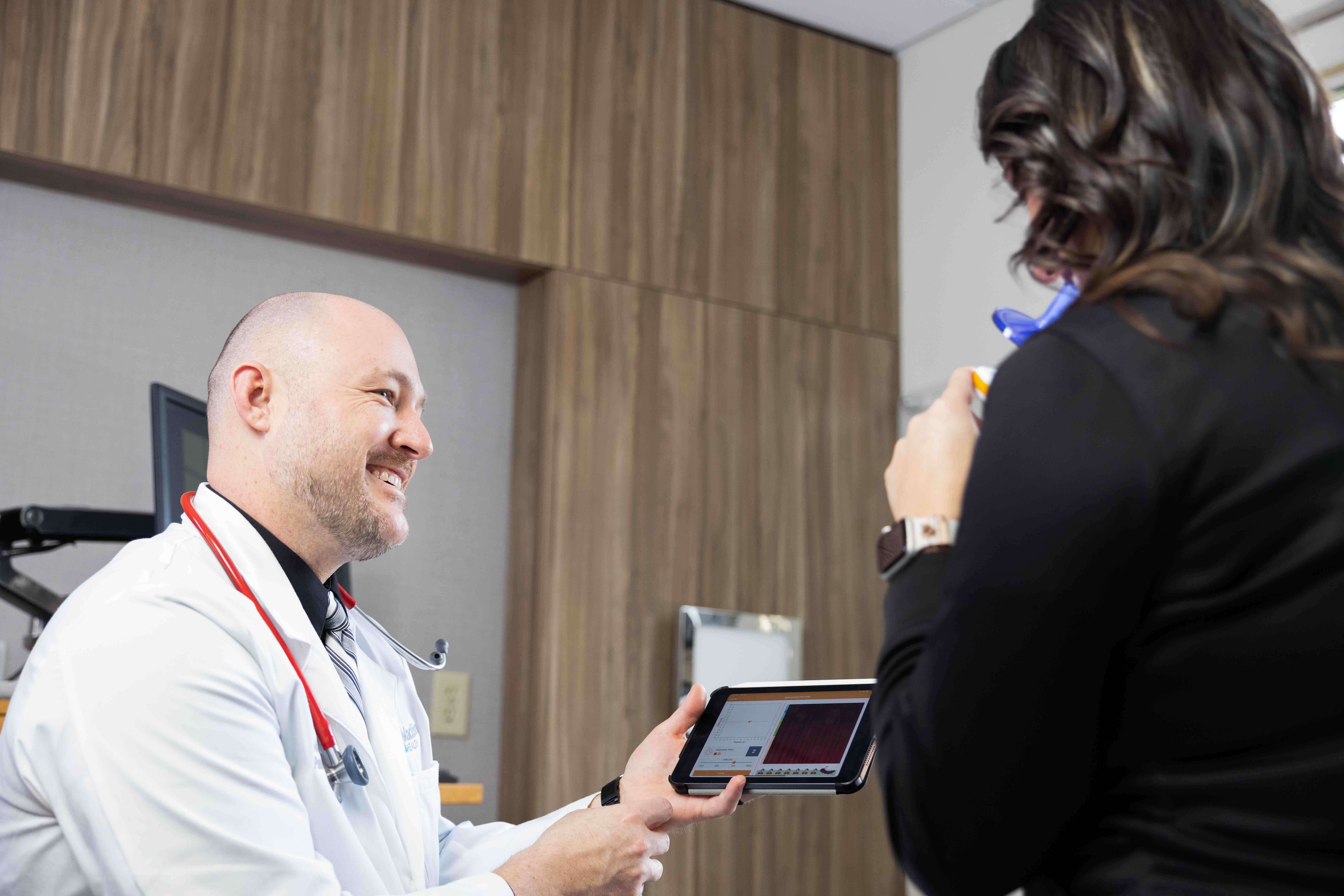 Doctor reviewing tablet with patient