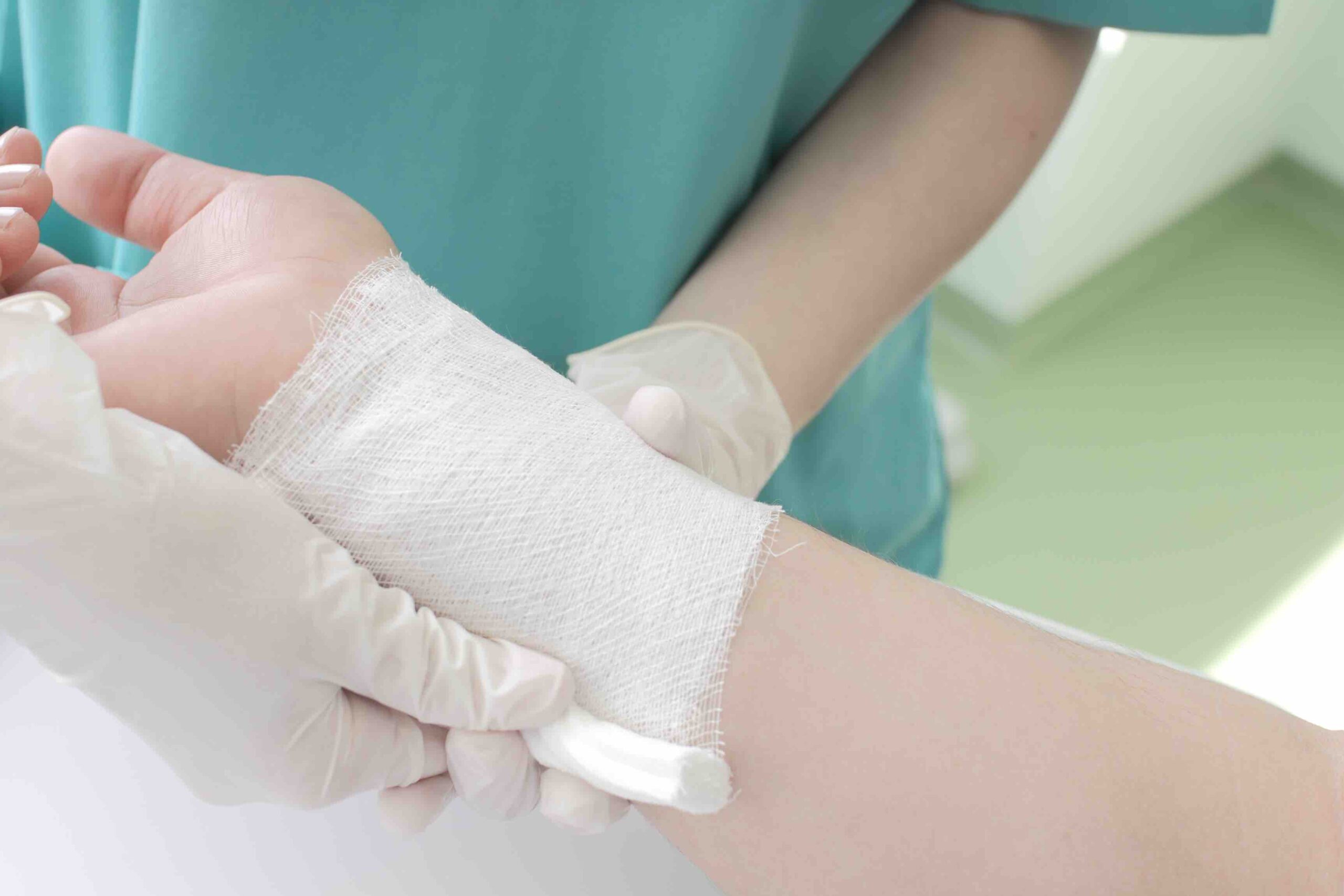 Doctor wrapping patient's wrist in gauze.