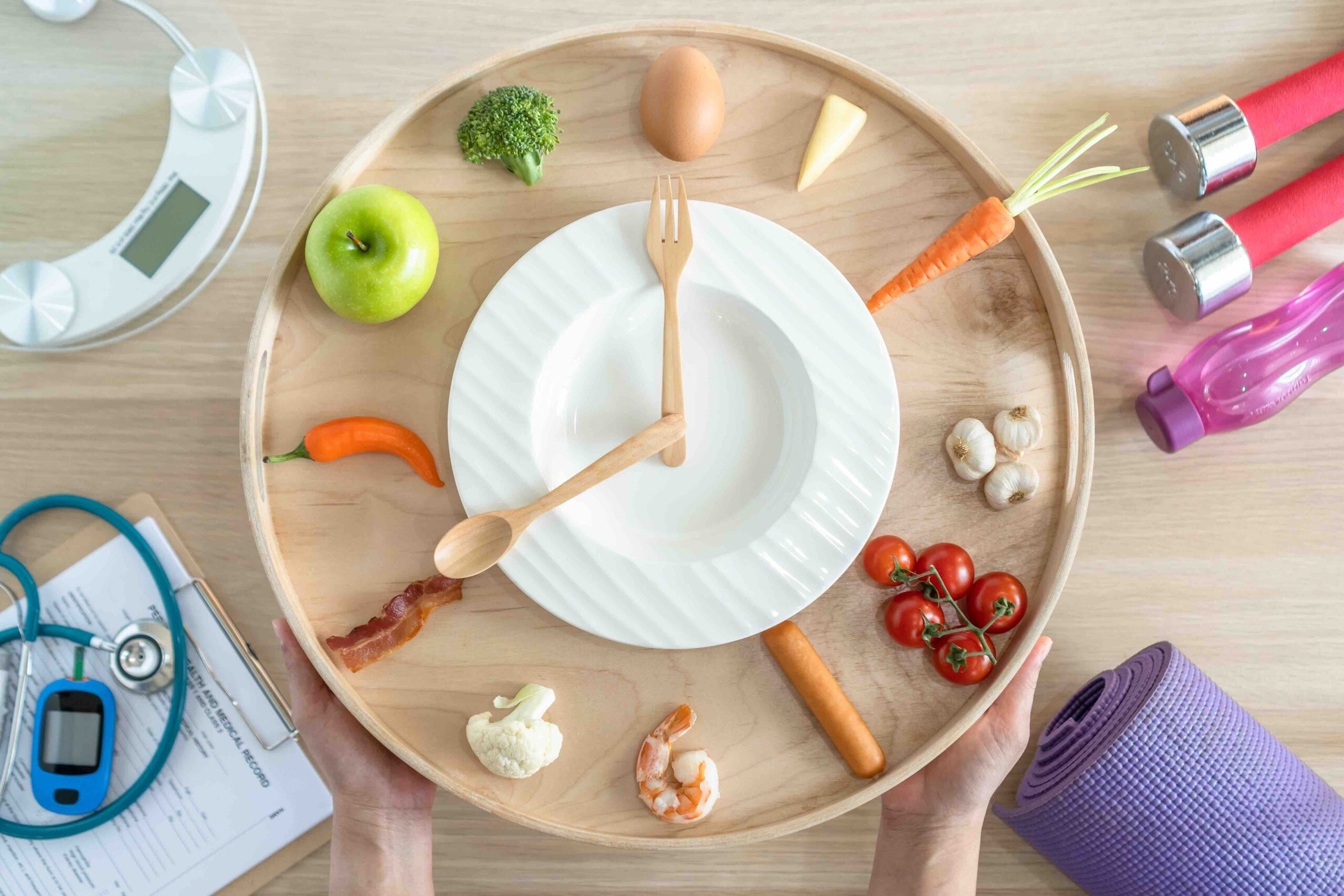 Intermittent fasting clock made with food and utensils.