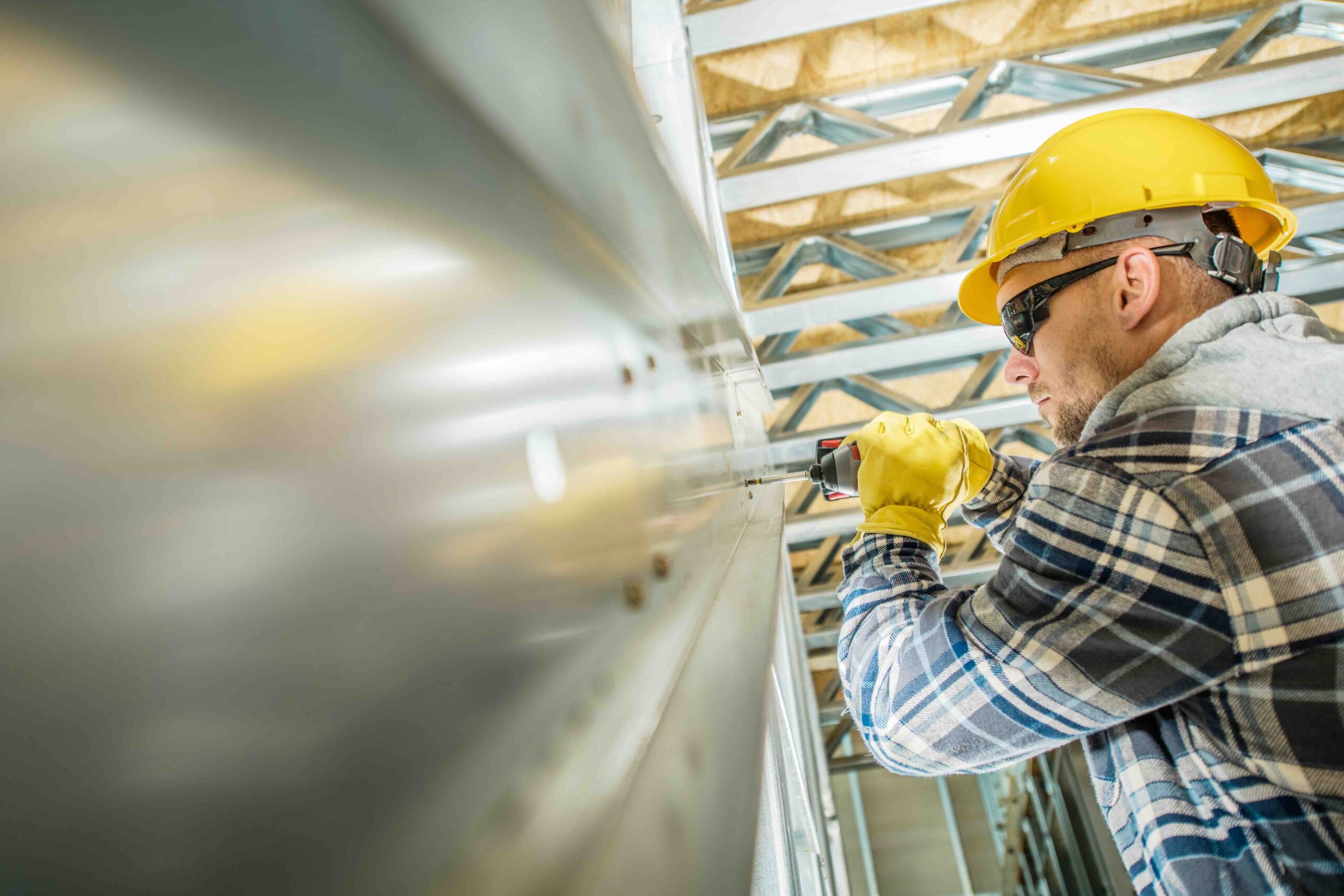 Madison Health, Occupational Health, Construction worker drilling into steel.