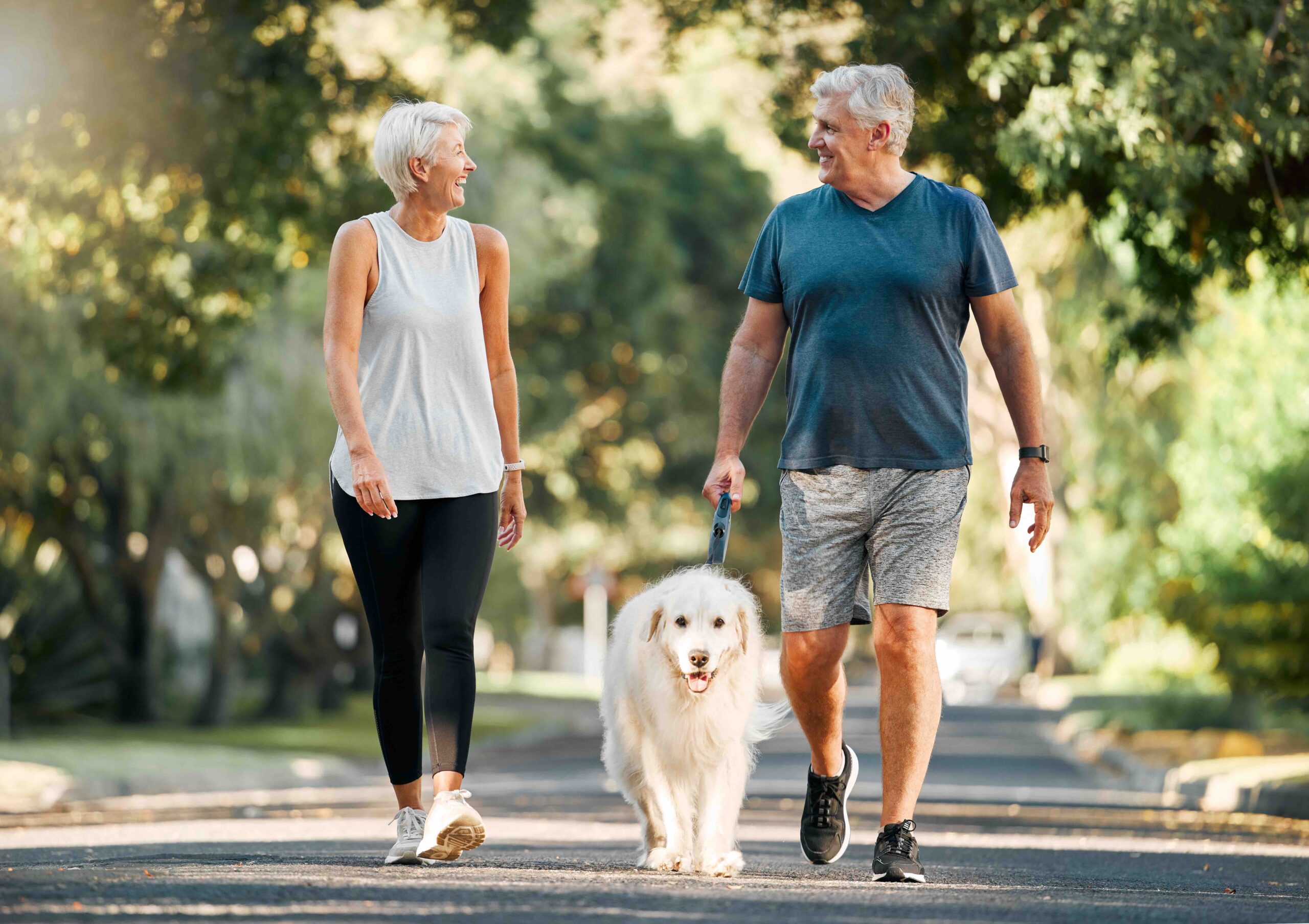 Retired couple walking with dog 